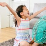 jeune fille devant un ventilateur en marche