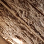 glass wool and styrofoam in a wooden frame on a inclined wall near the wooden ceiling and a window in a private house. warming the walls with fiberglass and foam plastic.