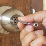 zoom sur une main qui tente d'ouvrir la serrure de sa porte