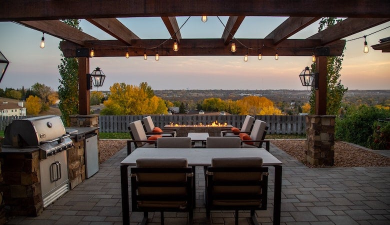 grande terrasse avec une table et des chaises au milieu. La terrasse surplombe la nature.