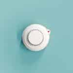 smoke fire detected smoke detector on light blue ceiling