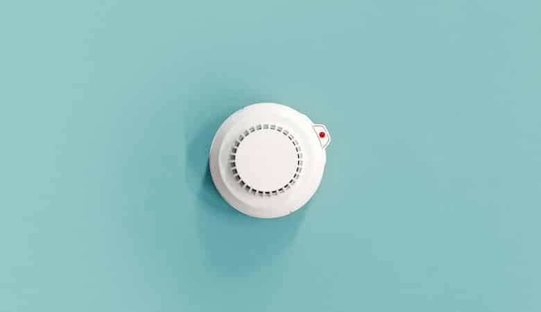 smoke fire detected smoke detector on light blue ceiling