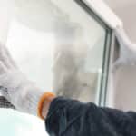 worker installing plastic window indoors, closeup view