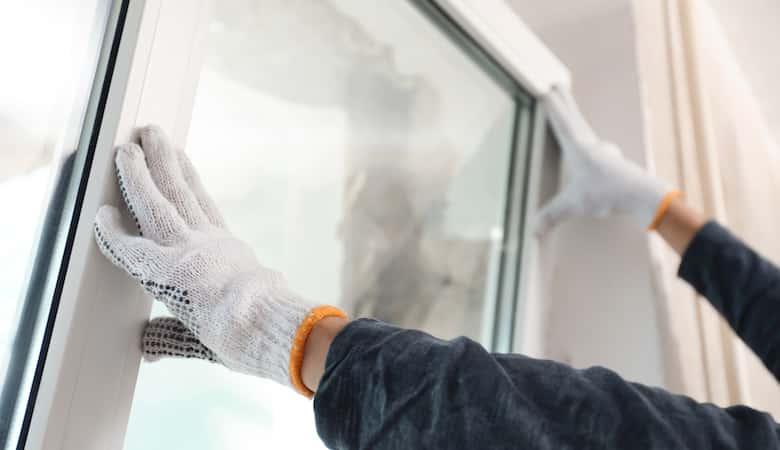 worker installing plastic window indoors, closeup view