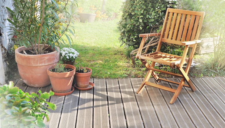 chair and potted plant on wooden terrace in summer