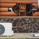 new modern hvac air conditioning external compressor unit preapred for installation or replacement near wall of wooden log residential country cottage. ladder and equipment for service and maintenance