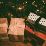 Cadeaux emballés avec du papier-cadeau et des rubans, posés au pied du sapin.