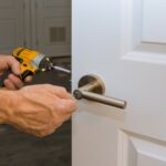 Serrurier installant une serrure sécurisée sur la porte de la maison