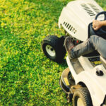 top view of man using lawn mower for cutting grass, portrait of healthy lifestyle and weekends