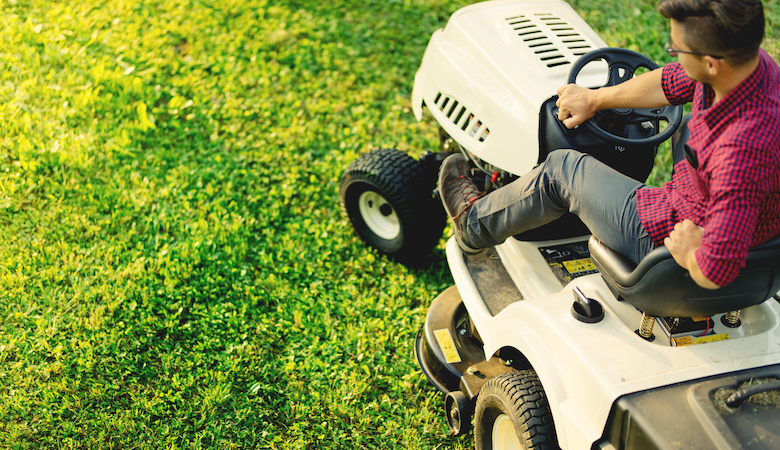 top view of man using lawn mower for cutting grass, portrait of healthy lifestyle and weekends