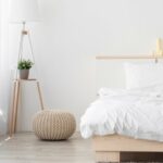 Chambre design dans les tons blancs, du mobilier en bois, avec un lit deux places