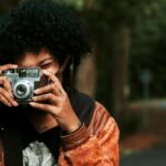 jeune femme qui prend une photo grâce à un appareil photo
