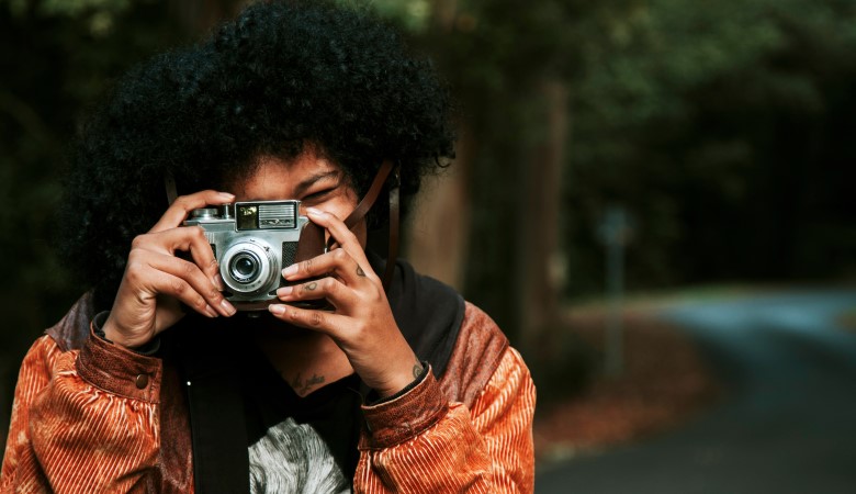 jeune femme qui prend une photo grâce à un appareil photo