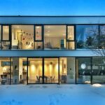 Maison moderne vu de face. Façade avec de grandes baies vitrées ouvrant sur l'intérieur du logement.