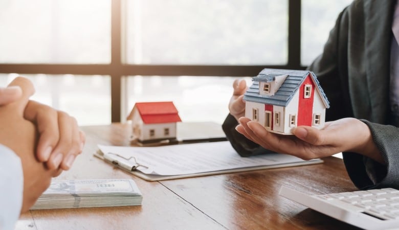 main qui tient une maison en maquette