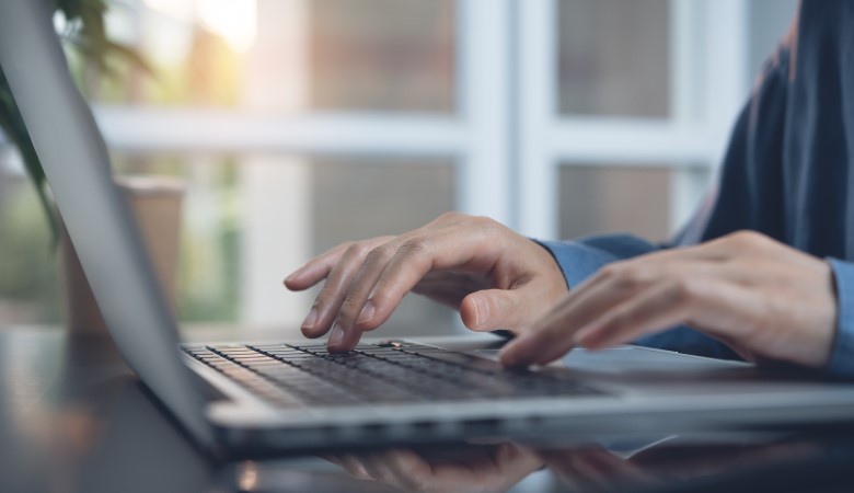 main de femme en train de taper sur l'ordinateur