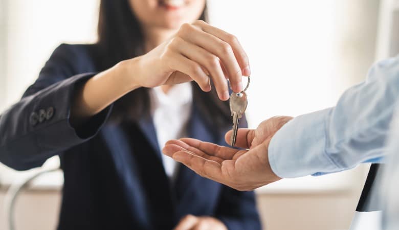 femme qui donne les clés d'un logement à un homme