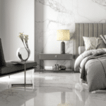 Une chambre avec un lit, un divan, une table de chevet, un vase et une plante. La chambre est revêtue de carrelage en marbre.