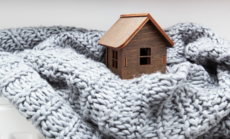 Petite maison en bois entourée d'une écharpe en laine?