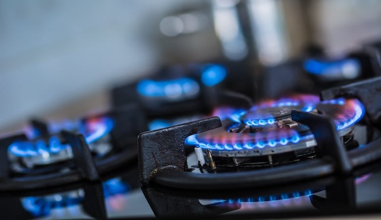 Une cuisinière à gaz avec le feu allumé.