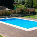 Piscine creusée avec du parquet qui l'entoure.