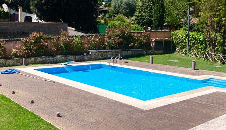 Piscine creusée avec du parquet qui l'entoure.