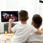 Père et fils regardant la télévision à la maison