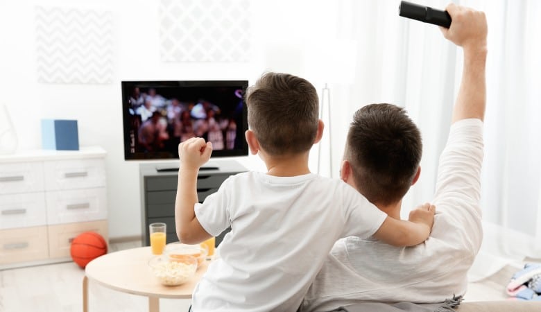 Père et fils regardant la télévision à la maison