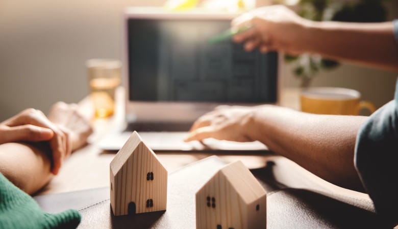 Agent immobilier expliquant un plan sur son ordinateur.