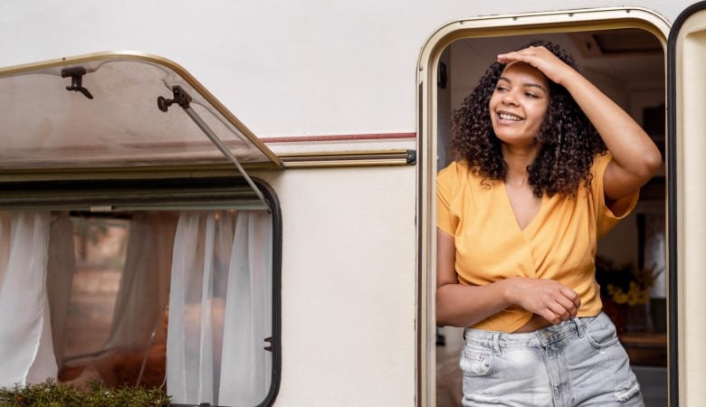 Jeune femme à la porte d'un mobile home