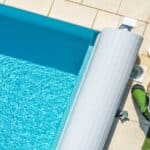 Vu d'en haut d'une piscine, avec un technicien changeant le filtre.