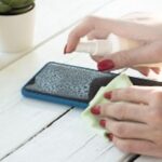 Une personne nettoyant son téléphone.