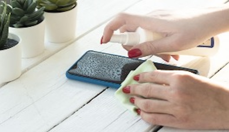Une personne nettoyant son téléphone.