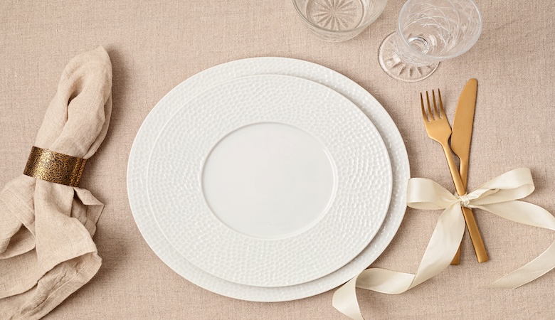 Une assiette avec ses couverts et verre ainsi qu'une serviette de table.