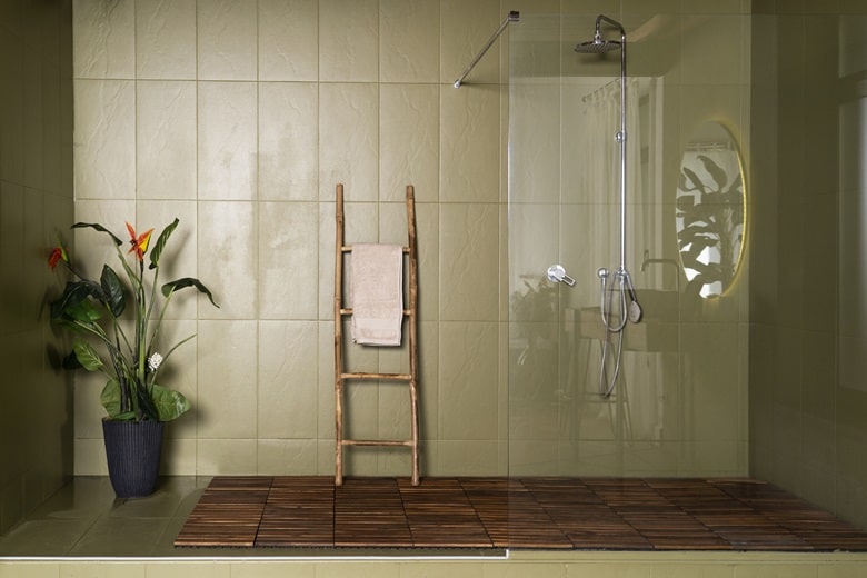 Salle de bain avec du carrelage olive au mur, une échelle décorative en bois et une douche à l'italienne.