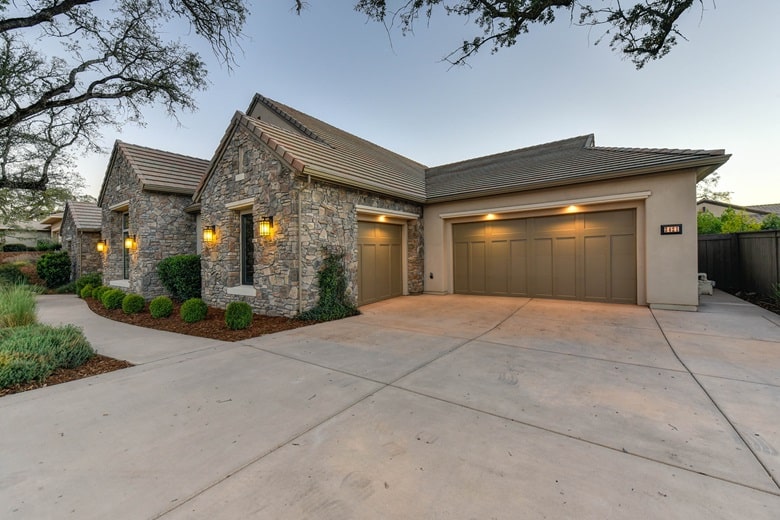 façade d'une maison en pierre avec un grand garage