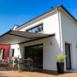 maison moderne, terrasse en bois et store banne