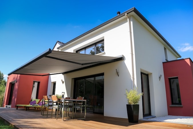 maison moderne, terrasse en bois et store banne