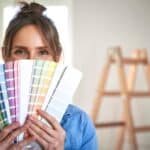 portrait en gros plan d'une femme se cachant derrière un échantillon de couleur