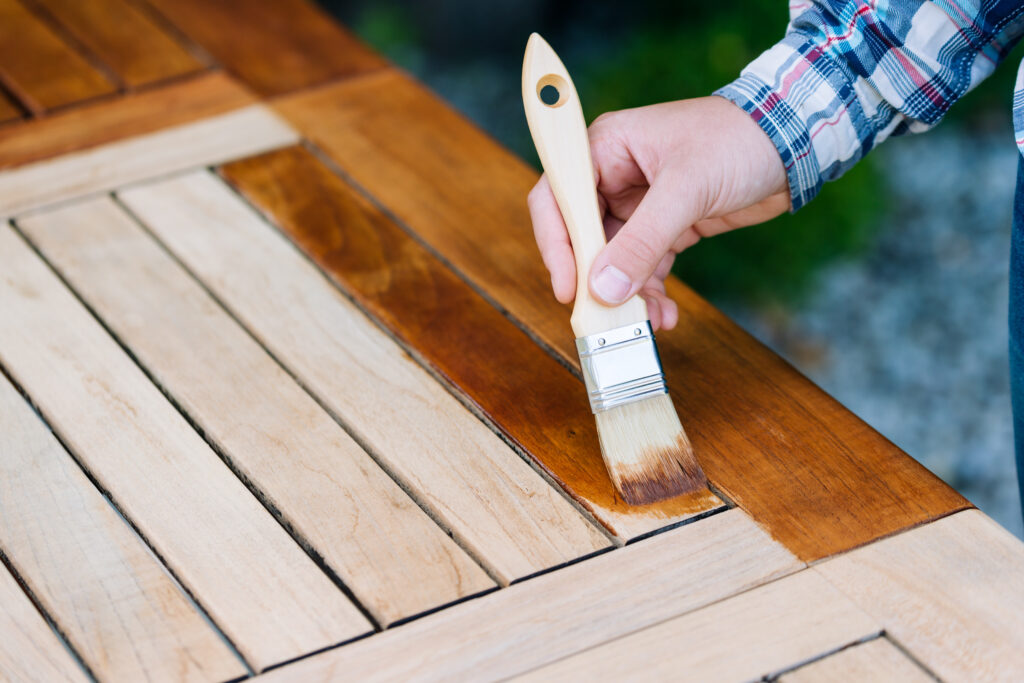 renovation of a garden table with a brush and oil