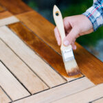 renovation of a garden table with a brush and oil