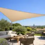 Voile d'ombrage triangulaire tendue au-dessus d'une terrasse ensoleillée